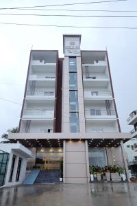 a large apartment building with a staircase in front of it at RV STAY INN in Yelahanka