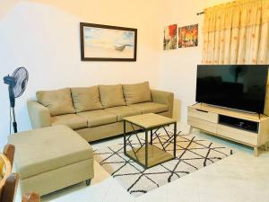 uma sala de estar com um sofá e uma televisão de ecrã plano em Awesome 2 bedrooms, living & dining area em General Trias