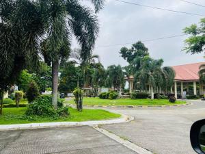 a house with palm trees in front of a street at Awesome 2 bedrooms, living & dining area in General Trias