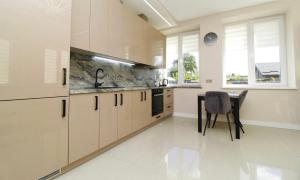 a kitchen with white cabinets and a table in it at Sodu apartment in Kaunas