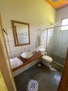 a bathroom with a sink and a toilet and a mirror at Pousada Vale dos Diamantes in Vargem Bonita