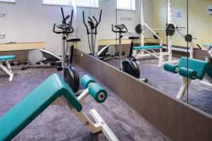 un gimnasio con varios equipos de ejercicio en una habitación en Hotel Wolfringmühle, en Fensterbach