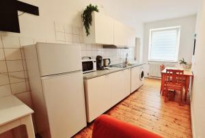 een keuken met witte apparatuur en een houten vloer bij ELENA flat LILIE, Oberhausen Zentrum CentrO Westfield in Oberhausen