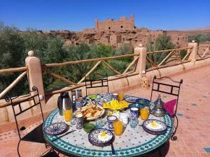 una mesa con comida y vistas a un castillo en Bab El Atlas en El Kelaa des Mgouna