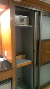 a kitchen cabinet with a microwave in it at Regent Plaza Hotel & Convention Center in Karachi