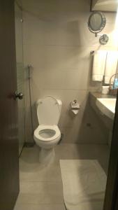 a bathroom with a white toilet and a sink at Regent Plaza Hotel & Convention Center in Karachi
