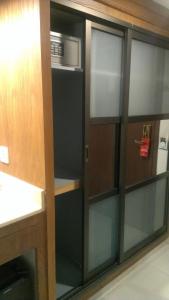 a kitchen with glass cabinets and a microwave at Regent Plaza Hotel & Convention Center in Karachi