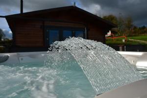 uma fonte de água numa piscina em Long Wood Lodges em Knighton