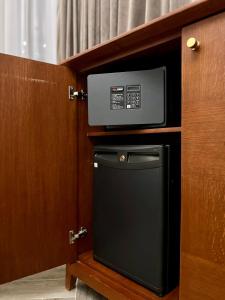 a microwave and a small refrigerator in a room at Bonita Inn in Amman