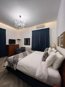 a bedroom with a large bed and a chandelier at Bonita Inn in Amman +83 photos