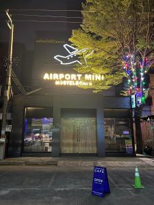 a store with an airport shuttle sign in front of it at Airport Mini Hostel at Don Muang Airport in Ban Don Muang