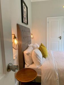 a bed with white pillows and a table in a room at Urban City Suites STUNNING Victorian 3 bed 2bath with free Parking in Birmingham