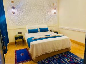 1 dormitorio con 1 cama grande con almohadas azules en Auberge Kasbah Ennakhile, en Nkob