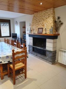 uma sala de estar com lareira e uma mesa e cadeiras em Allotjament Rural Casa Bernat em Sapeira