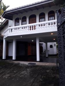 - un bâtiment blanc avec un balcon au-dessus dans l'établissement Ceylon Travel and Stay Lodge, à Battaramulla