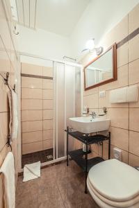a bathroom with a sink and a toilet and a mirror at Taormina Garden Hotel in Taormina