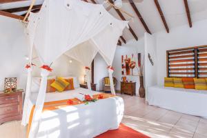 1 dormitorio con 1 cama blanca en una habitación en Coco Beach Resort, en Port Vila