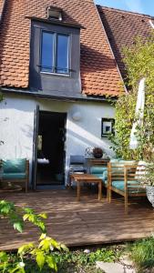 eine Holzterrasse mit Bänken, einem Tisch und einem Gebäude in der Unterkunft Atelier & Gardenhouse Glamping in München