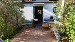 a porch with chairs and a table and a door at Atelier & Gardenhouse Glamping in Munich