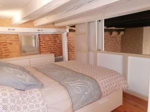 um quarto com uma cama num pequeno quarto em A DEUX PAS em Bergerac
