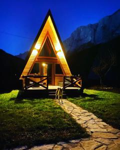 a small cabin with lights on the side of it at Etno apartmani Komarnica in Šavnik