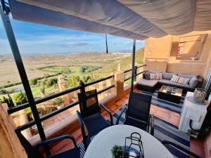 a balcony with a table and chairs and a couch at Magnificent apartment Mar'y'Golf with SPECTACULAR VIEW! High-speed internet, Remote Work in Mojácar