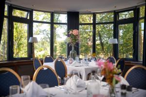 een eetkamer met tafels, stoelen en ramen bij Van der Valk Hotel de Bilt-Utrecht in De Bilt