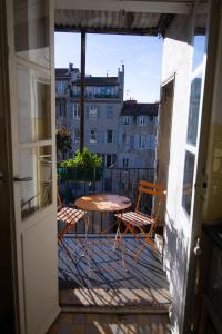 um pátio com uma mesa e cadeiras numa varanda em Jolie chambre dans appartement cosy en plein centre em Marselha