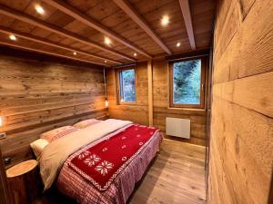 a bedroom in a log cabin with a bed in it at Splendide appartement style chalet classé 4 étoiles, terrasse face à la montagne in La Bresse