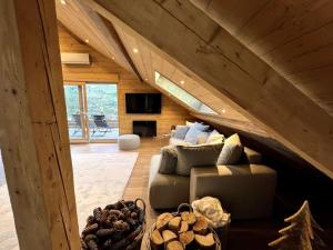 a living room with a couch in the attic at Splendide appartement style chalet classé 4 étoiles, terrasse face à la montagne in La Bresse