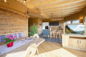 een keuken en een woonkamer met een tafel en stoelen bij Bio-Chalet Haus Wagner in Niederndorf