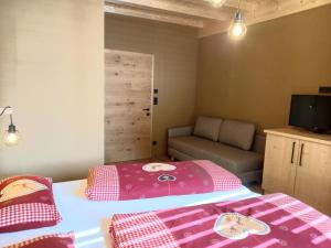 een kleine slaapkamer met een bed en een bank bij Bio-Chalet Haus Wagner in Niederndorf