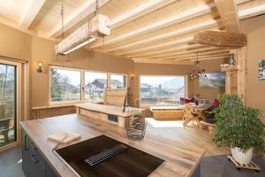 a large kitchen with wooden ceilings and a dining room at Bio-Chalet Haus Wagner in Niederndorf