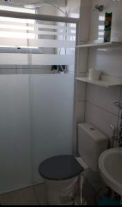 a white bathroom with a toilet and a sink at Blue Ubatuba in Ubatuba