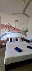 a bedroom with two beds with a painting on the wall at Blue Turtle Hotel in Tissamaharama