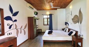 ein Schlafzimmer mit einem Bett in einem Zimmer in der Unterkunft Blue Turtle Hotel in Tissamaharama