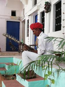 Człowiek w czerwonym kapeluszu trzymający karabin w obiekcie Shiva Guest House w mieście Pushkar