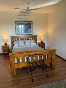 a bedroom with a large wooden bed with two lamps at Tunnel Ridge Outlook in Mooloolah