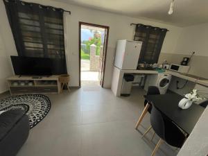 ein Wohnzimmer mit einem Kühlschrank und einem Tisch in der Unterkunft Maison de Bourda in Cayenne