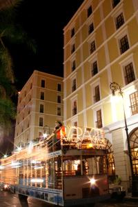 a double decker bus driving past a building at night at Gran Hotel Diligencias in Veracruz