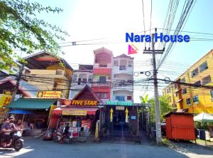 un edificio con un cartel que lee la casa narmada en Nara House en Chiang Mai