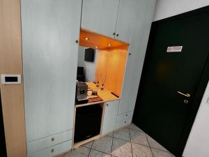 eine kleine Küche mit einer Spüle und einer Mikrowelle in der Unterkunft Casa Carlotta in Follonica
