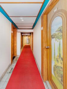 um tapete vermelho caminha por um corredor com uma porta e um corredor vermelho em Hotel KGN - Mumbai em Mumbai