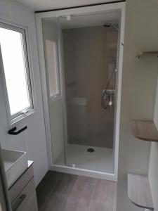 y baño con ducha y puerta de cristal. en Mobil Home 4-6 personnes, en Gastes