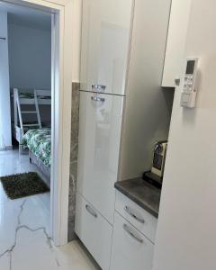 a kitchen with white cabinets and a glass refrigerator at apartment Julija in Okrug Donji