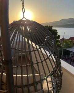 una jaula de aves con la puesta de sol en el fondo en apartment Julija en Donji Okrug