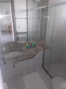 uma casa de banho com um lavatório e um chuveiro em Acomodação Cecília. em Campos dos Goytacazes