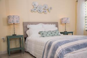 奧喬里奧斯的住宿－Hey Love，一间卧室配有一张带两张桌子和两盏灯的床。