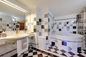 een badkamer met een zwart-wit geruite vloer bij Velký 3-ložnicový byt Praha 8 Karlín in Praag