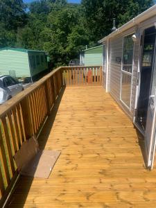 a wooden deck next to a mobile home at Devine Staycations at 38 Riverside in Hawick